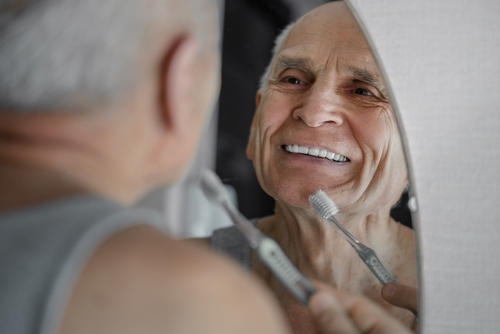 older man brushing his teeth